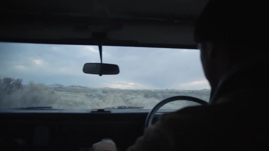 A person is driving in a car on a road