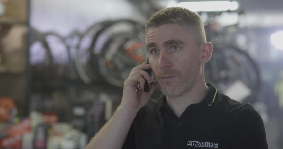 A bicycle shop employee works in the shop