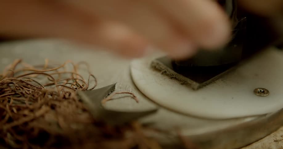 A person cuts out a piece for a belt