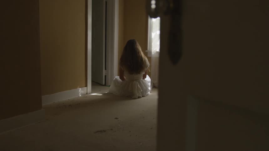 A young girl sitting in a hallway