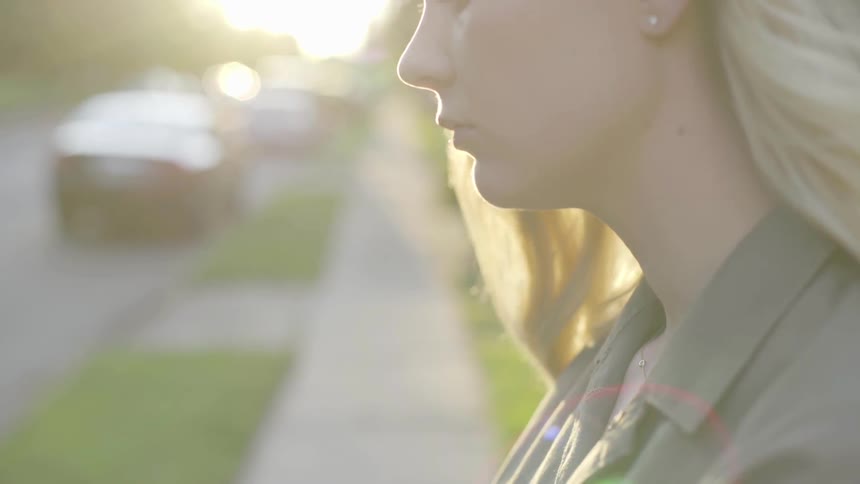 A woman staring at a car on the street