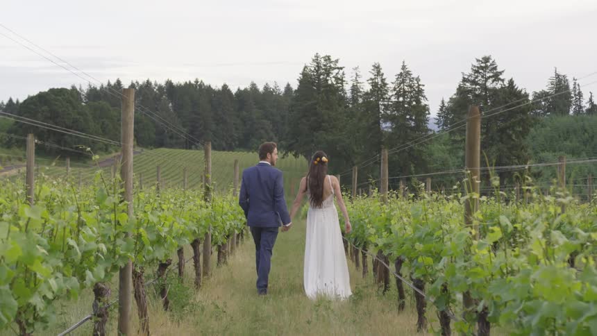 A man and a woman walking on a fenced path