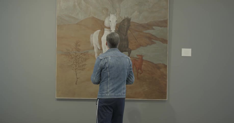 Man examines painting of two horses and a dog