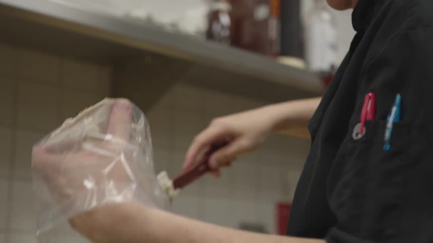 A person filling a bag with a frosting