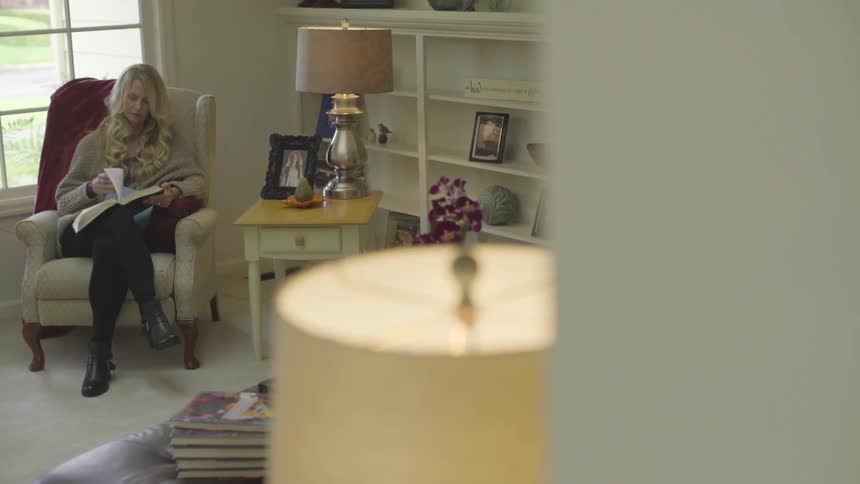 Panning shot of a woman reading a book