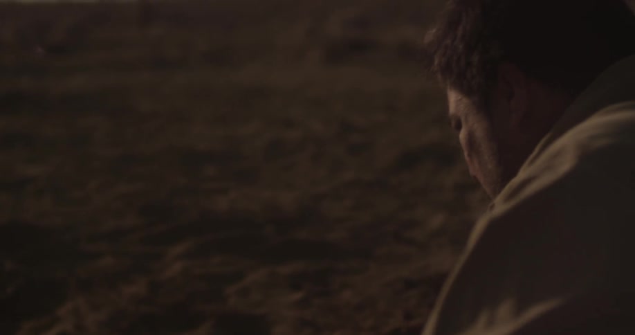 Man stands in a dusty desert on a sunny day