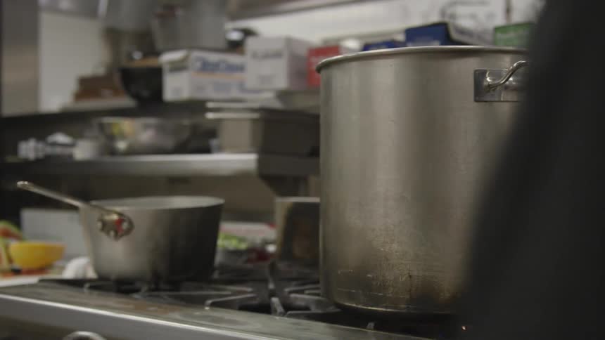A pair of pots sitting on a stove in a kitchen