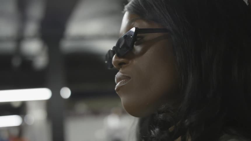 A woman wearing sunglasses looks into the distance in front of her