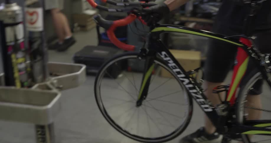 Man puts bicycle up on display in a bike shop