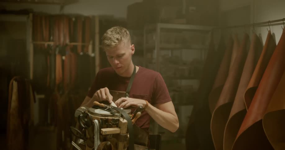 Leather smith works on a belt