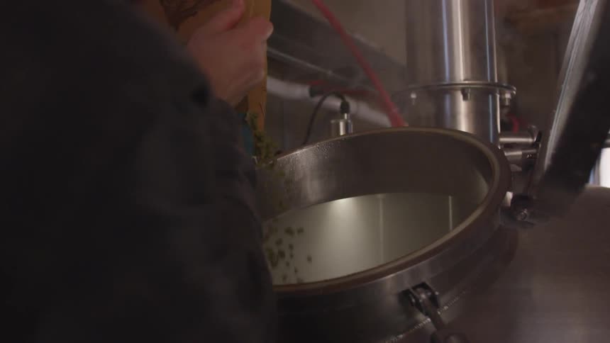 Adding hops into a large metal drum