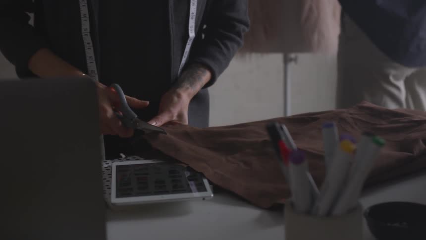 Man cutting a piece of cloth at an art table