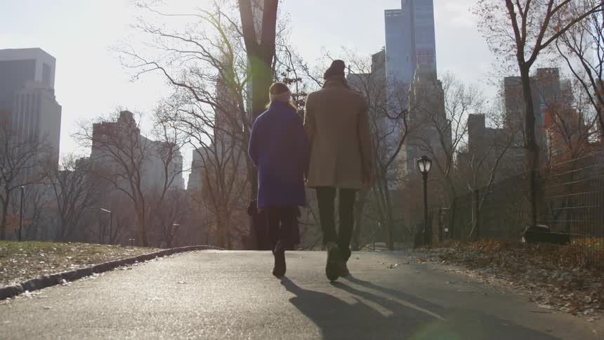 An old couple walks on a path in a park