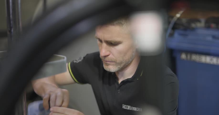 Man cleans part of bicycle seat tube