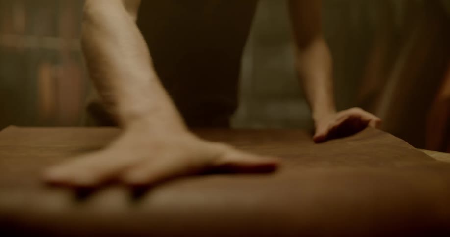 Man selects large piece of leather and lays it on table