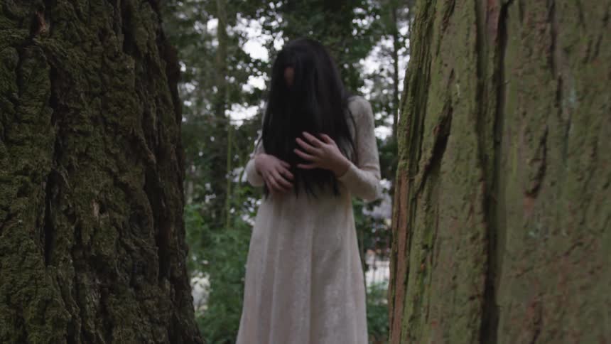 A woman is standing in a forest