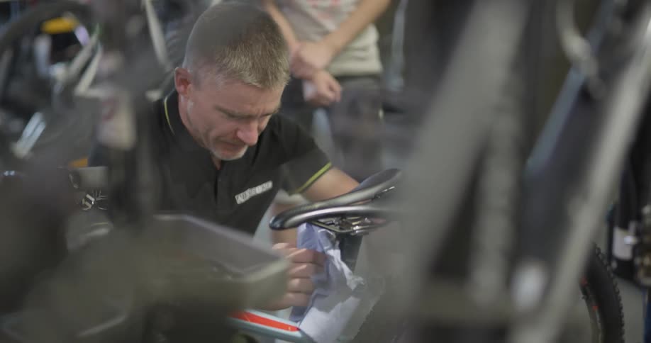 A bicycle shop employee works in the shop