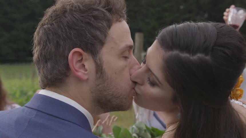 A man and woman kissing each other at a wedding