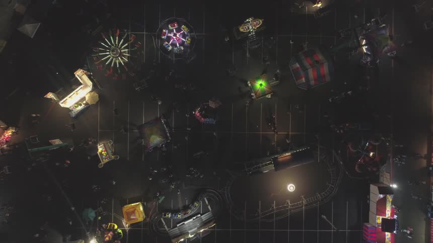 A carnival that is set up in a parking lot at night