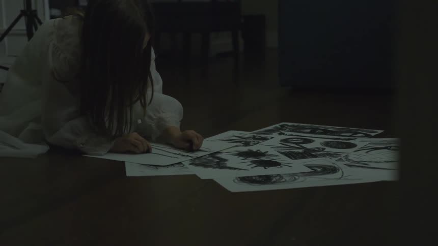 A girl drawing with charcoal on a floor
