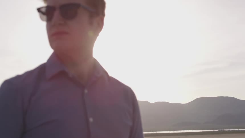A man in sunglasses standing outdoors during the day