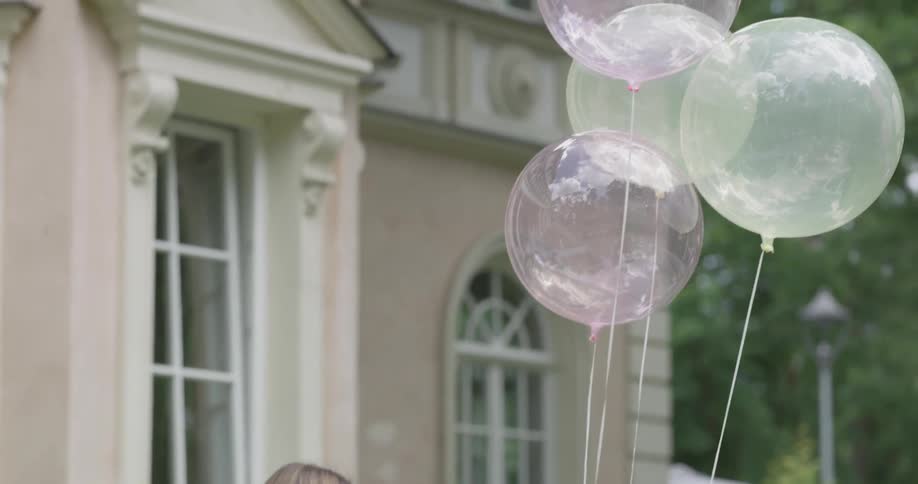 A woman sets down weighted helium balloons