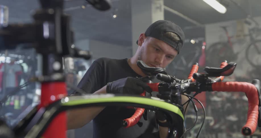 A bicycle shop employee works on a bike