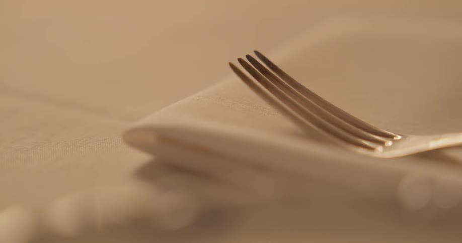 Cutlery being placed on a linen lined table
