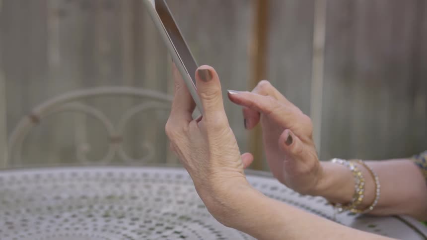 A woman using a tablet outdoors