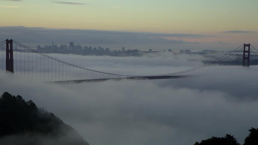 A lot of clouds rolling in over a bridge