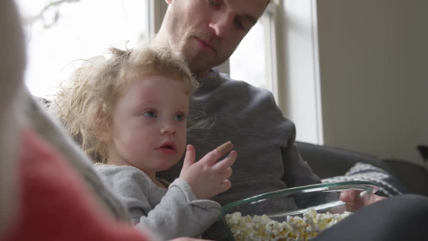 A man and girl eating popcorn