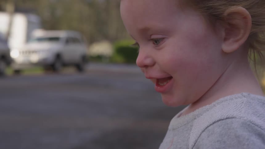 Young child smiles and turns toward camera