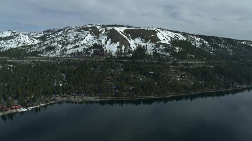 A large lake next to the base of a mountain