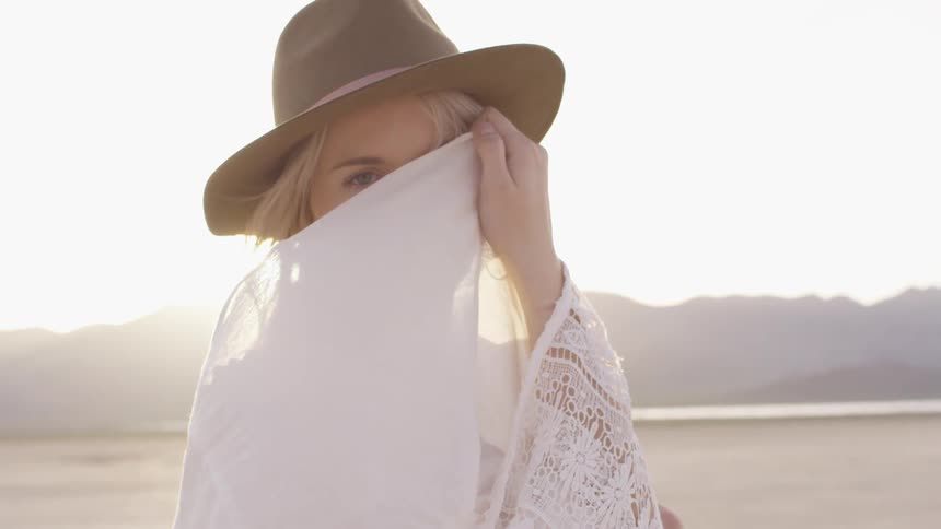 A woman uses a shawl to hide her face
