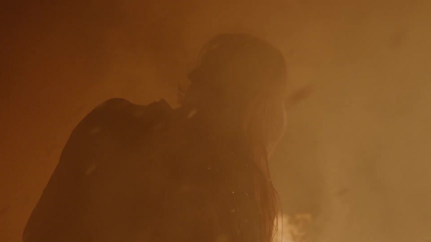 A man and woman kissing in front of a fire