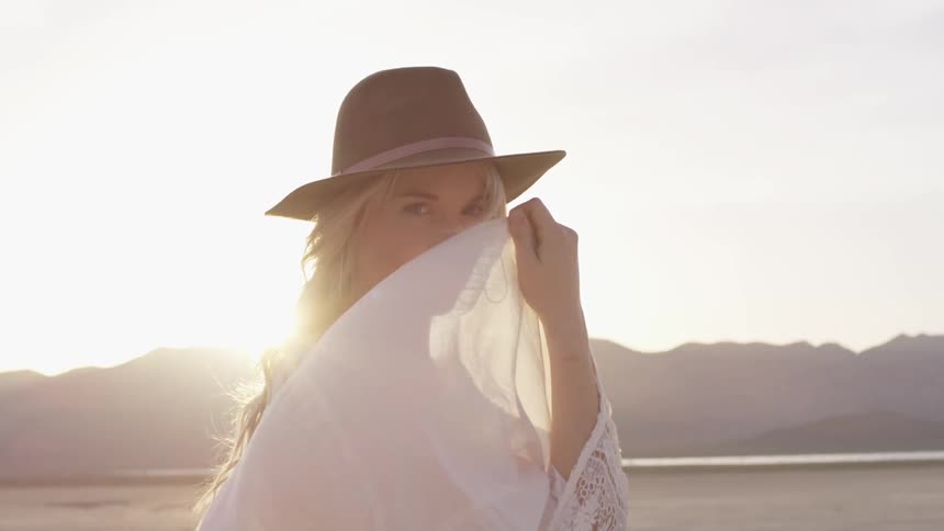 A woman in a white dress standing in a desert valley