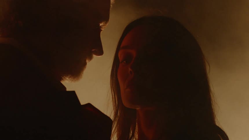 A man and woman standing in front of a fire