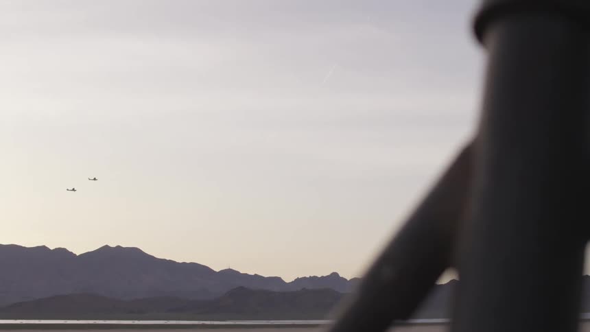 Planes fly low over mountains in the distance