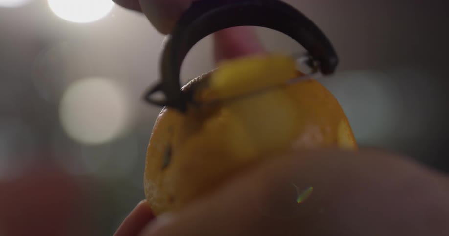 A person is peeling an orange