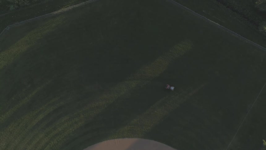 Lawn mower can be seen cutting the grass or maybe it's a tractor trimming the field of a large farm of green grassy area
