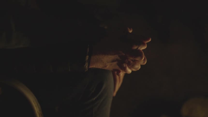 A man and woman hold hands at night near a fire