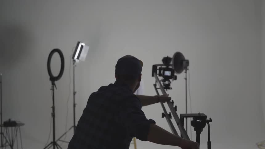 A man taking photos of a woman in a studio