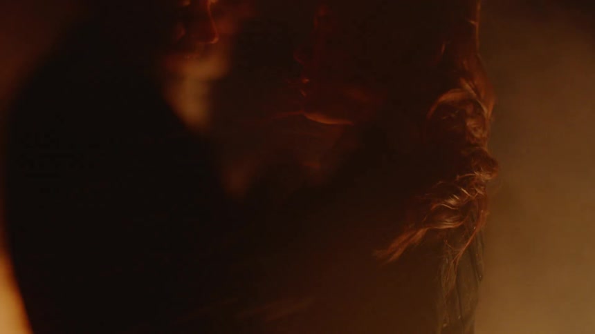A man and woman hold each other in front of a fire