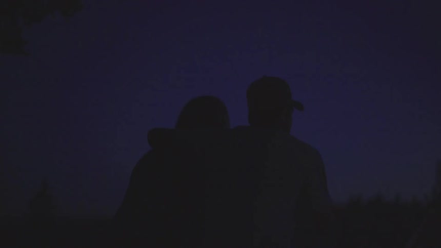 Man and woman sit together gazing into the night sky