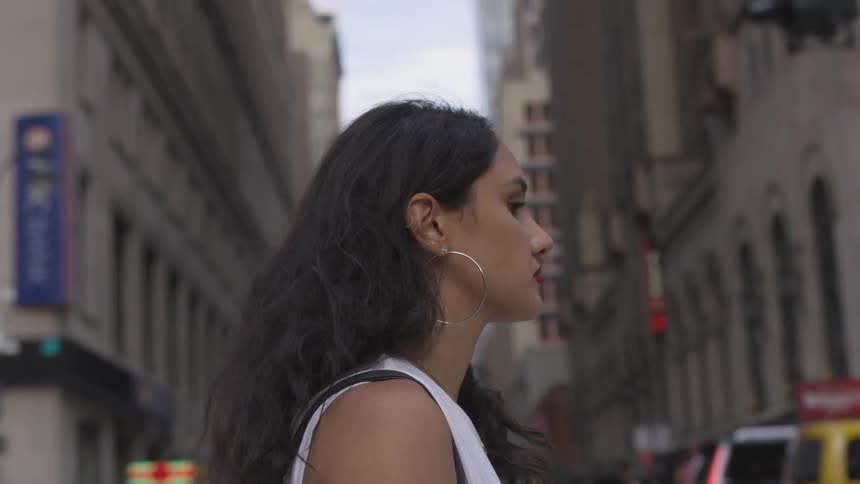 A woman is walking outside in the city