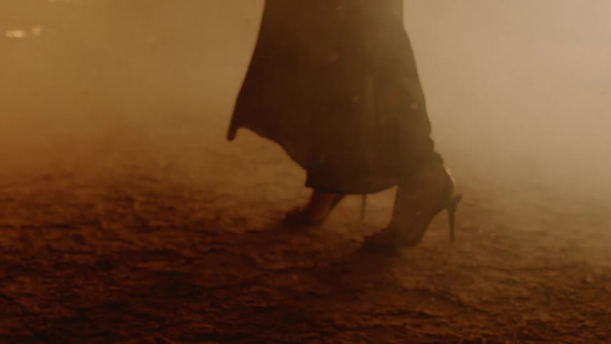 A woman is by a fire and there is ash