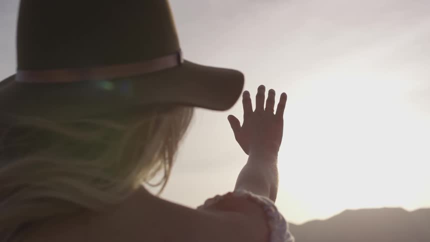 A woman wearing a hat looking into the sun