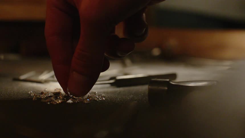 A person is picking up diamonds from a table