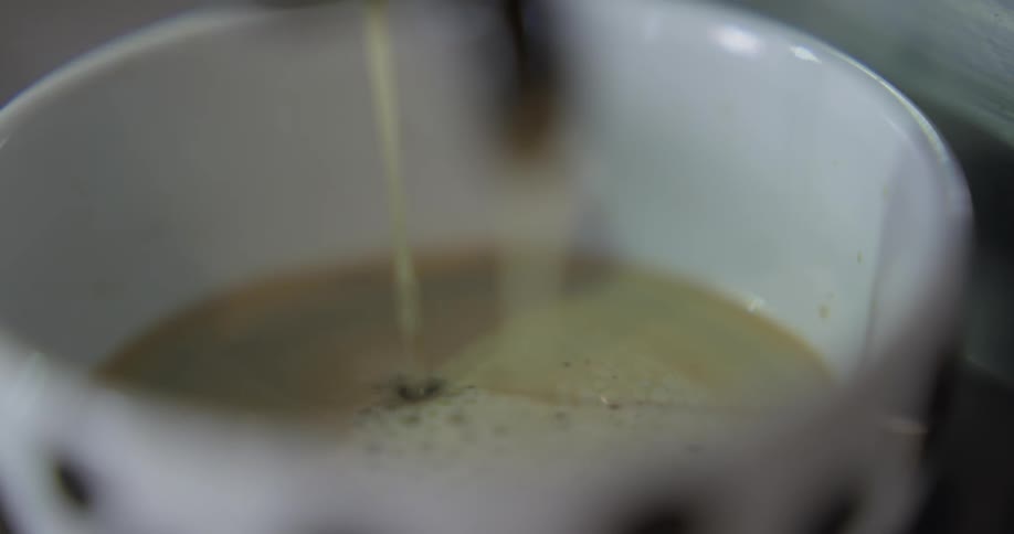 Liquid is being poured into a cup slowly