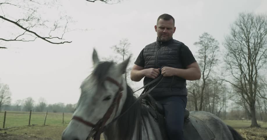A man climbs up and rides a horse